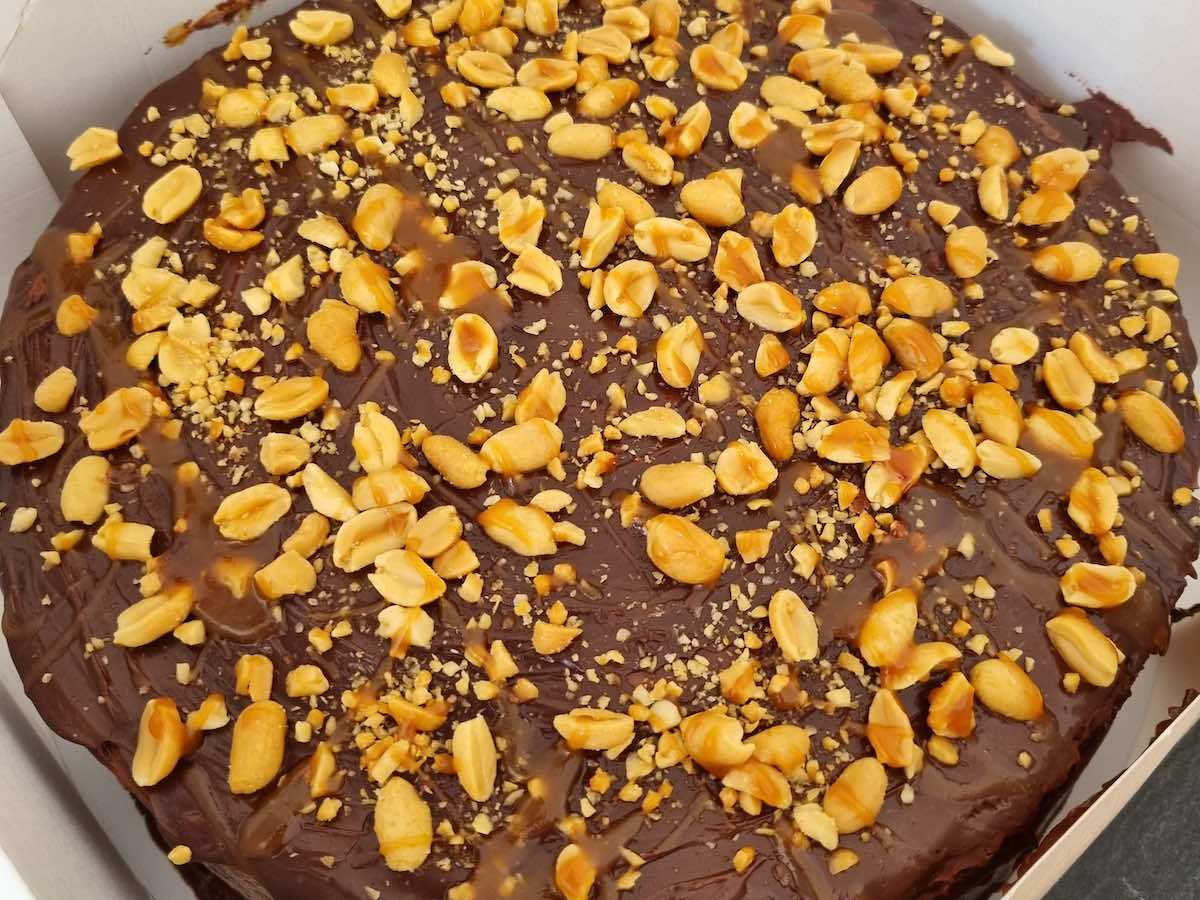 large chocolate cake covered in peanuts