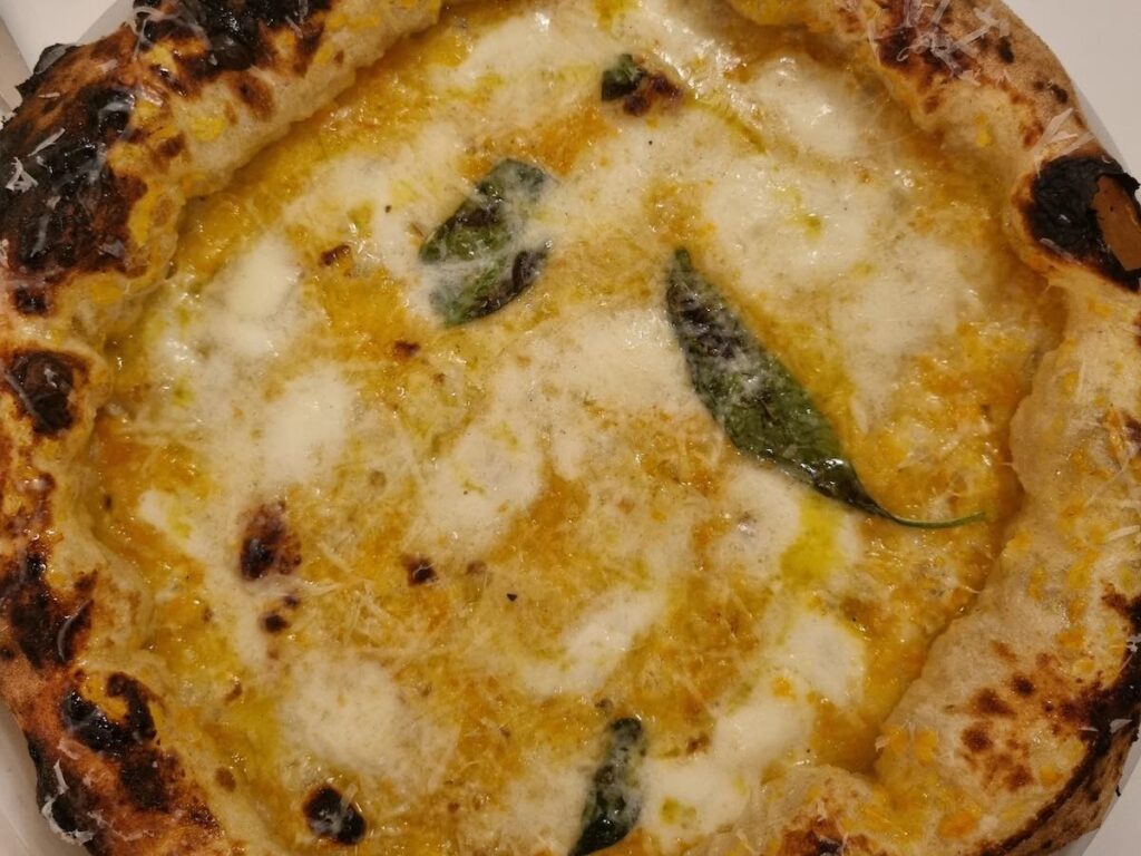 nNea pizza with yellow tomato sauce