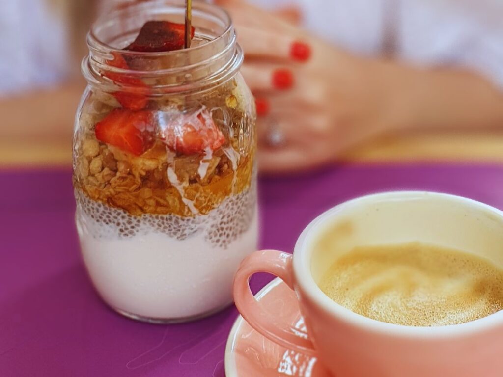 Brunch in Barcelona at Lato Cafe. The chia pudding with peanut butter and strawberries. With a latte in a pink cup